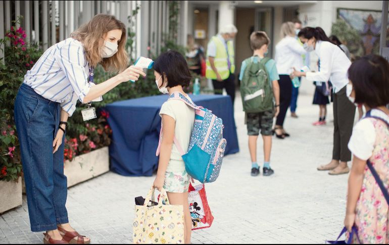 BARCELONA. Una trabajadora toma la temperatura a una niña en el ingreso de un colegio privado.