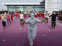 Un instructor de gimnasia dirige hoy a enfermos de COVID-19 en un hotel designado para tratar a pacientes asintomáticos en Karawaci, Indonesia. AFP/A. Berry