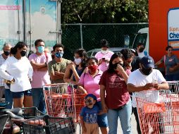 Personas portan mascarillas mientras se forman para ingresar a un supermercado previo a la llegada del ciclón. XINHUA/E. Rosas