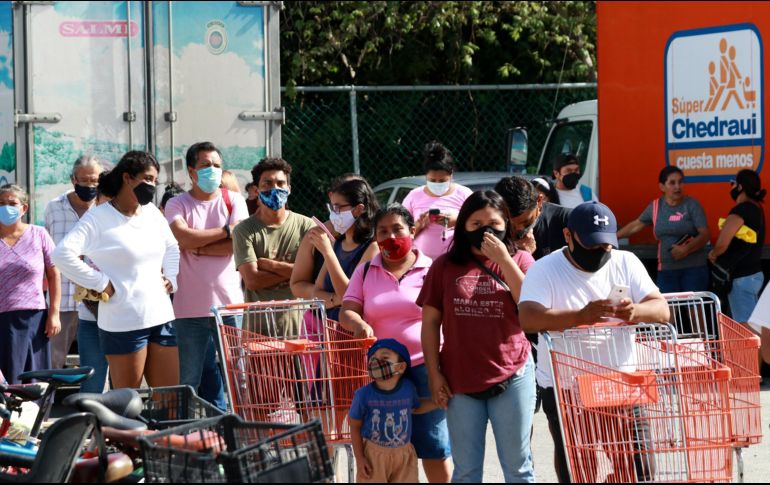 Personas portan mascarillas mientras se forman para ingresar a un supermercado previo a la llegada del ciclón. XINHUA/E. Rosas
