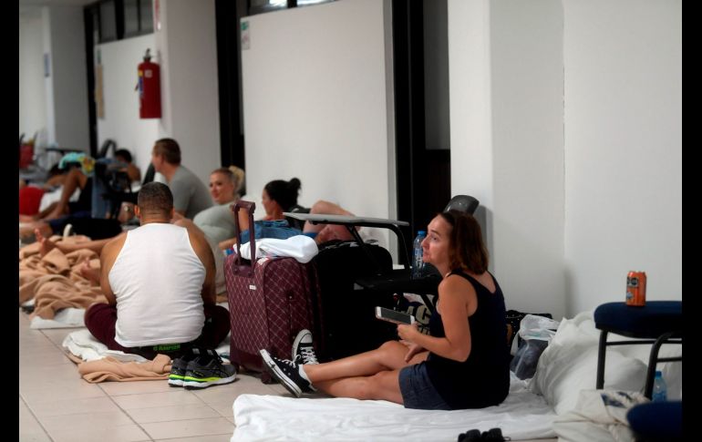 Turistas aguardan en un refugio en Cancún. AFP/P. Pardo