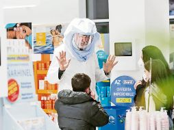 El trabajador de una farmacia en Roma recuerda a los clientes las medidas de higiene ante posibles contagios. EFE/G. Lami