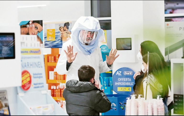 El trabajador de una farmacia en Roma recuerda a los clientes las medidas de higiene ante posibles contagios. EFE/G. Lami