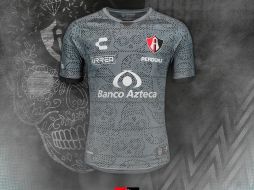 El traje es color gris y negro, con un estampado de calaveras de dulce, tradicionales del Día de Muertos. TWITTER / @atlasfc
