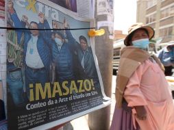 Una mujer pasa junto a un periódico con una foto del presidente electo Luis Arce celebrando su victoria, este martes, en La Paz. EFE/J. Alves