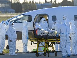 Personal médico sube a un paciente con COVID-19 para su evacuación en el aeropuerto en Saint-Gilles, Francia. AFP/P. Guyot