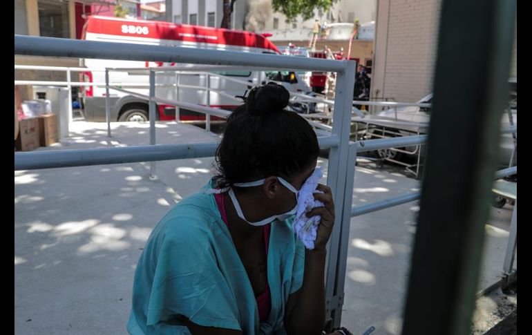 El fuego y el denso humo negro que salía del hospital generó nerviosismo y provocó apuro entre los enfermeros y médicos. EFE/A. Lacerda