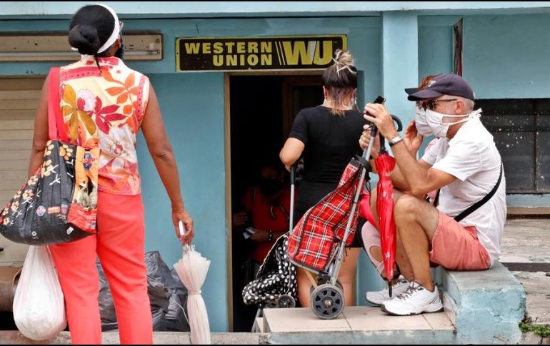 Varias personas esperan al frente de una oficina de Western Union, en La Habana. EFE/ARCHIVO