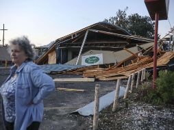 Una mujer permanece enfrente de un restaurante destruido luego del paso del huracán 