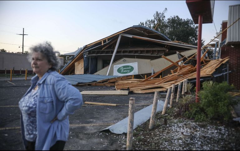 Una mujer permanece enfrente de un restaurante destruido luego del paso del huracán 