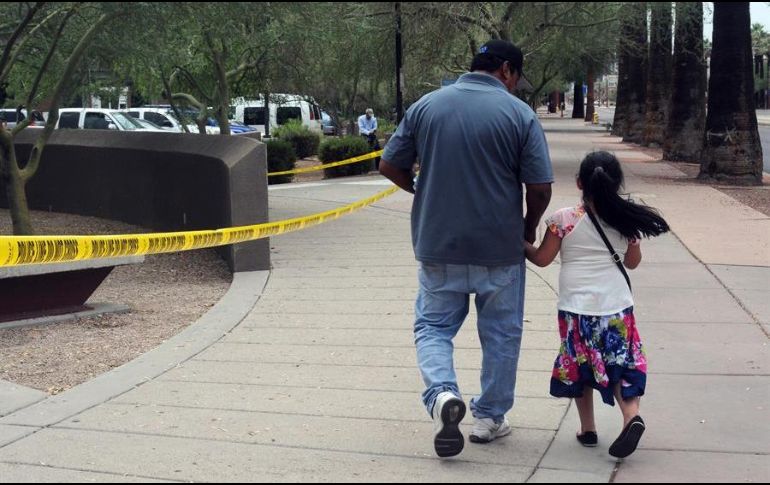 Un hombre camina junto a su hija tras salir de una cita en la Oficina de Control de Inmigración y Aduanas (ICE), en centro de Phoenix. EFE/B. Limón