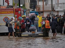 Policías estatales evacuan a familias de una zona inundada en San Cristóbal de las Casas, Chiapas. EFE/C. López