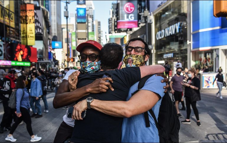 Ciudadanos se abrazan por el triunfo del candidato demócrata este sábado, en Times Square, Nueva York. AFP / S. Keith