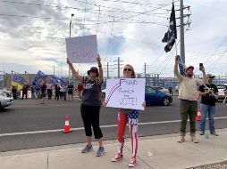 Seguidores del presidente Donald Trump sostienen pancartas y banderas durante una protesta en Phoenix, Arizona. EFE/A. Segura