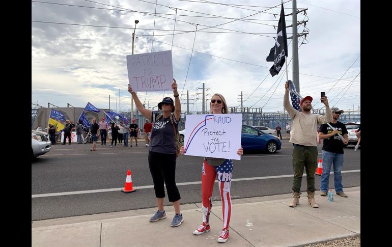 Seguidores del presidente Donald Trump sostienen pancartas y banderas durante una protesta en Phoenix, Arizona. EFE/A. Segura