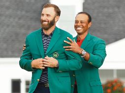 JÚBILO. Johnson (izq.) recibió la tradicional chaqueta verde de manos de Tiger Woods, quien era el campeón defensor del Masters de Augusta. AFP• P. Smith