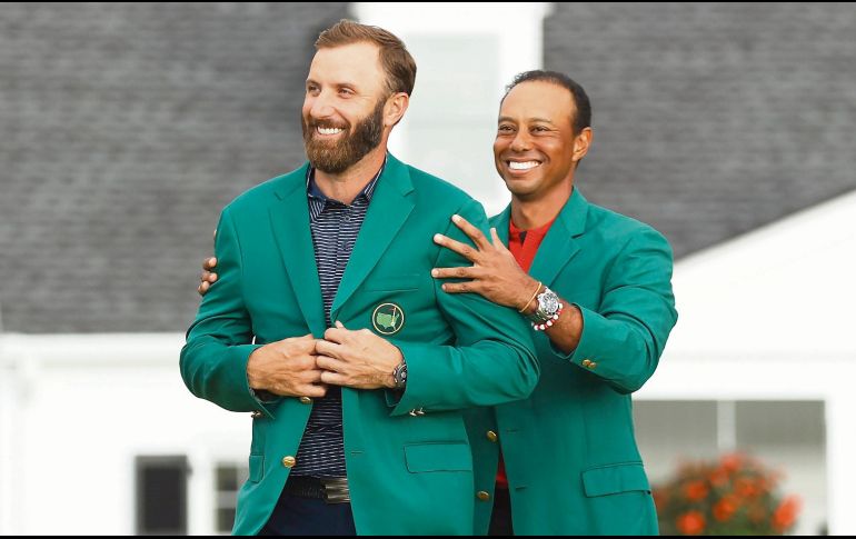 JÚBILO. Johnson (izq.) recibió la tradicional chaqueta verde de manos de Tiger Woods, quien era el campeón defensor del Masters de Augusta. AFP• P. Smith