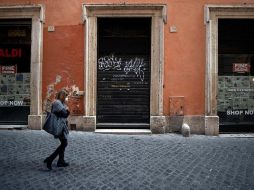 Una mujer camina por calles desiertas de Roma, en medio de la segunda ola de coronavirus que afectó al país. EFE/M. Percossi