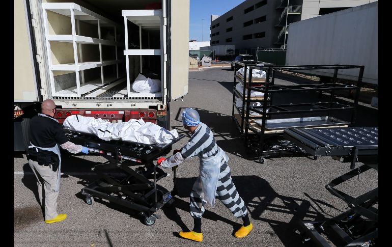 Un preso trabaja en el traslado de cuerpos a un camión refrigerado instalado temporalmente afuera de la oficina forense de El Paso, en una imagen del 17 de noviembre. AFP/M. Tama