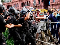 Varias personas saltaron los vallados de la Casa Rosada e ingresaron a la misma. La policía utilizó gases lacrimógenos para controlar la situación. AFP / R. Schemidt