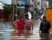 Varias personas cruzan una calle inundada en Pondicherry. EFE