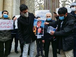 DESCONTENTO. Estudiantes queman las imágenes de Donald Trump y Joe Biden en la capital iraní. AFP