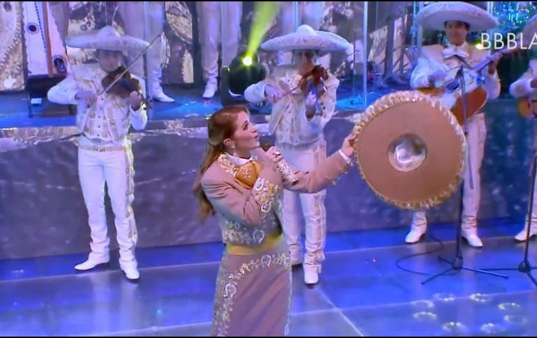 En punto de las 21 horas tiempo de México, la llamada ''Novia de América''hizo su aparición ataviada con un bello traje de charro en color café y amarillo. TWITTER / @LuceroMexico