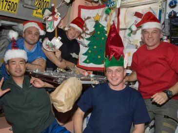 Cinco miembros de la tripulación de la Expedición 22 de Soichi Noguchi, izquierda, Maksim V. Surayev , Oleg V. Kotov, Timothy J. Creamer y Jeffrey N. Williams alrededor de la mesa de la cena de Navidad en 2009. ESPECIAL/ www.nasa.gov