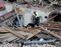 Un trabajador de los servicios de emergencia busca con un perro entre los escombros de los edificios dañados por el terremoto. EFE/A. Bat