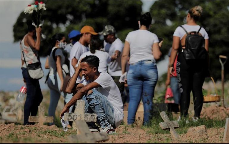 Una familia de venezolanos llora la muerte de su padre por coronavirus, durante el entierro en el cementerio de Caju en la zona norte de Río de Janeiro. EFE/A. Lacerda