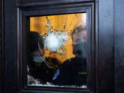 Policías observan desde un vidrio roto del Capitolio después del asalto a la institución por parte de manifestantes pro-Trump. EFE/M. Reynolds