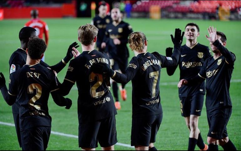 Jugadores del FC Barcelona celebran el cuarto gol ante el Granada, durante el partido disputado en el estadio Nuevo los Cármenes. EFE/M. Molina