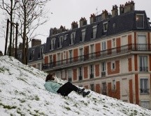 Una mujer protegida con cubrebocas se desliza por las laderas nevadas de Montmartre. EFE/I. Langsdon