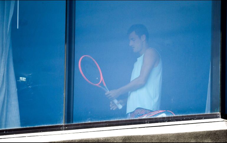 El tenista Bernard Tomic se ejercita hoy en un cuarto de hotel en Melbourne. Hay 72 tenistas en confinamiento estricto en sus habitaciones de hotel. AFP/W. West