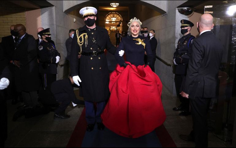 ESPECTACULAR. Lady Gaga se presentó en la toma de posesión de Joe Biden con un vestido diseñado por Daniel Roseberry, director de la firma Schiaparelli. Consistió en una chaqueta entallada en cachemir azul marino, acompañado por una falda faille de seda roja de gran volumen. Destacó un broche en forma de paloma dorada cerca de su hombro, que más de algún travieso confundió con el logo de “Los Juegos del Hambre”. EFE