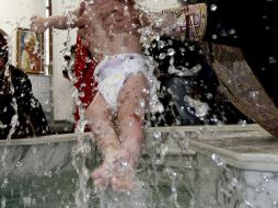 Cumpliendo con el ritual ortodoxo, el infante fue sumergido tres veces en el agua bendita a pesar de que lloraba mucho. EFE / ARCHIVO