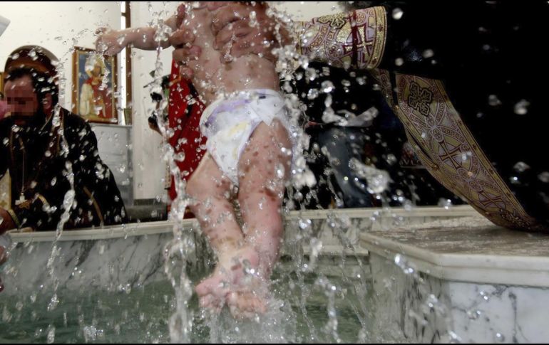 Cumpliendo con el ritual ortodoxo, el infante fue sumergido tres veces en el agua bendita a pesar de que lloraba mucho. EFE / ARCHIVO