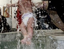Cumpliendo con el ritual ortodoxo, el infante fue sumergido tres veces en el agua bendita a pesar de que lloraba mucho. EFE / ARCHIVO