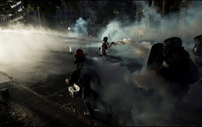 Manifestantes levantaron barricadas en varias calles de la ciudad mientras agentes antidisturbios los enfrentaban con gases lacrimógenos y carros lanzaagua. EFE/A. Valdés