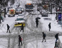 En Nueva York, que enfrenta su tercera tormenta de nieve del invierno, se registraban siete centímetros de nieve en algunos puntos. Peatones cruzan una avenida en la zona de Queens. AP/F. Franklin II