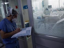 Un médico revisa el estado de un paciente afectado por COVID-19 en la Unidad de Cuidados Intensivos del Hospital Clínico de la Universidad de Chile. EFE/A. Valdés