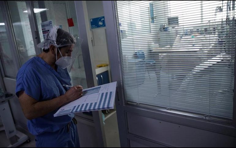 Un médico revisa el estado de un paciente afectado por COVID-19 en la Unidad de Cuidados Intensivos del Hospital Clínico de la Universidad de Chile. EFE/A. Valdés