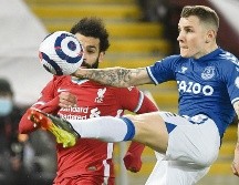 EN UN TOBOGÁN. Lucas Digne, de Everton, le gana el balón a Mohamed Salah, de los Reds. AP