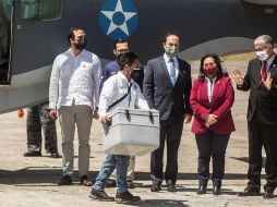 Un trabajador del Gobierno de Guatemala transporta vacunas (caja gris) donadas por Israel mientras ante la mirada del embajador de Israel en Guatemala (d), en el aeropuerto internacional La Aurora. EFE/E. Biba