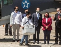 Un trabajador del Gobierno de Guatemala transporta vacunas (caja gris) donadas por Israel mientras ante la mirada del embajador de Israel en Guatemala (d), en el aeropuerto internacional La Aurora. EFE/E. Biba