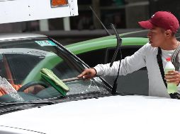 Rodrigo, un trabajador informal, limpia parabrisas en una de las principales calles de la Ciudad de México. EFE / M. Guzmán