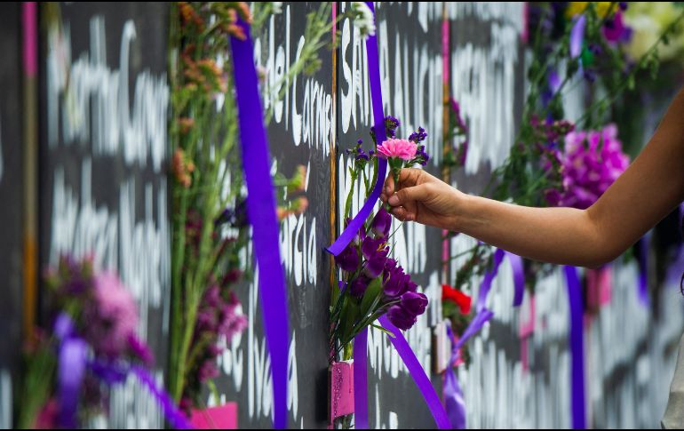Continúa el movimiento de personas que llegan a la valla frente a Palacio Nacional para colocar flores y velas para recordar a mexicanas víctimas de la violencia. AFP/ARCHIVO