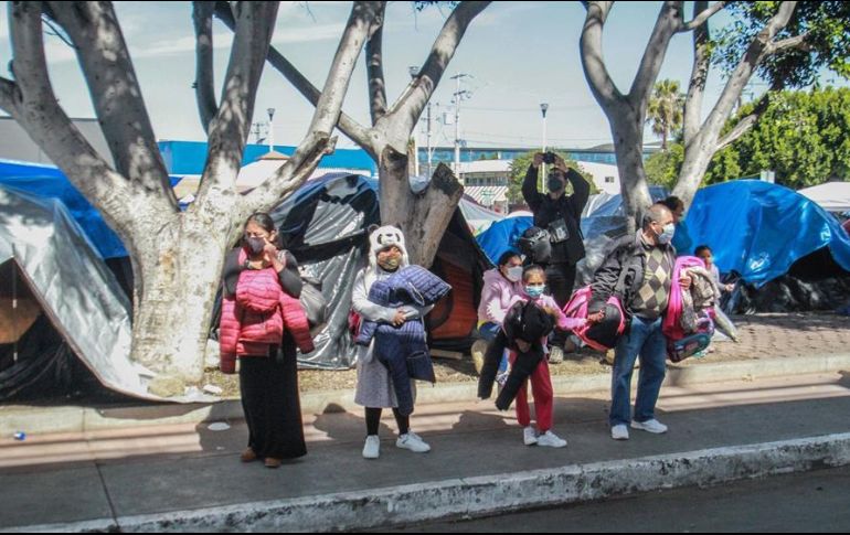 Un grupo de niños observa a migrantes que protestan en un campamento instalado en las inmediaciones del puerto fronterizo del Chaparral, en Tijuana. EFE/J. Terríquez