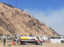 Brigadistas forestales coordinan la recarga de agua para las aeronaves. ESPECIAL