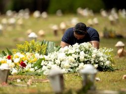 Un hombre visita una tumba en el cementerio Campo de Esperanza, en Brasilia. EFE/J. Alves